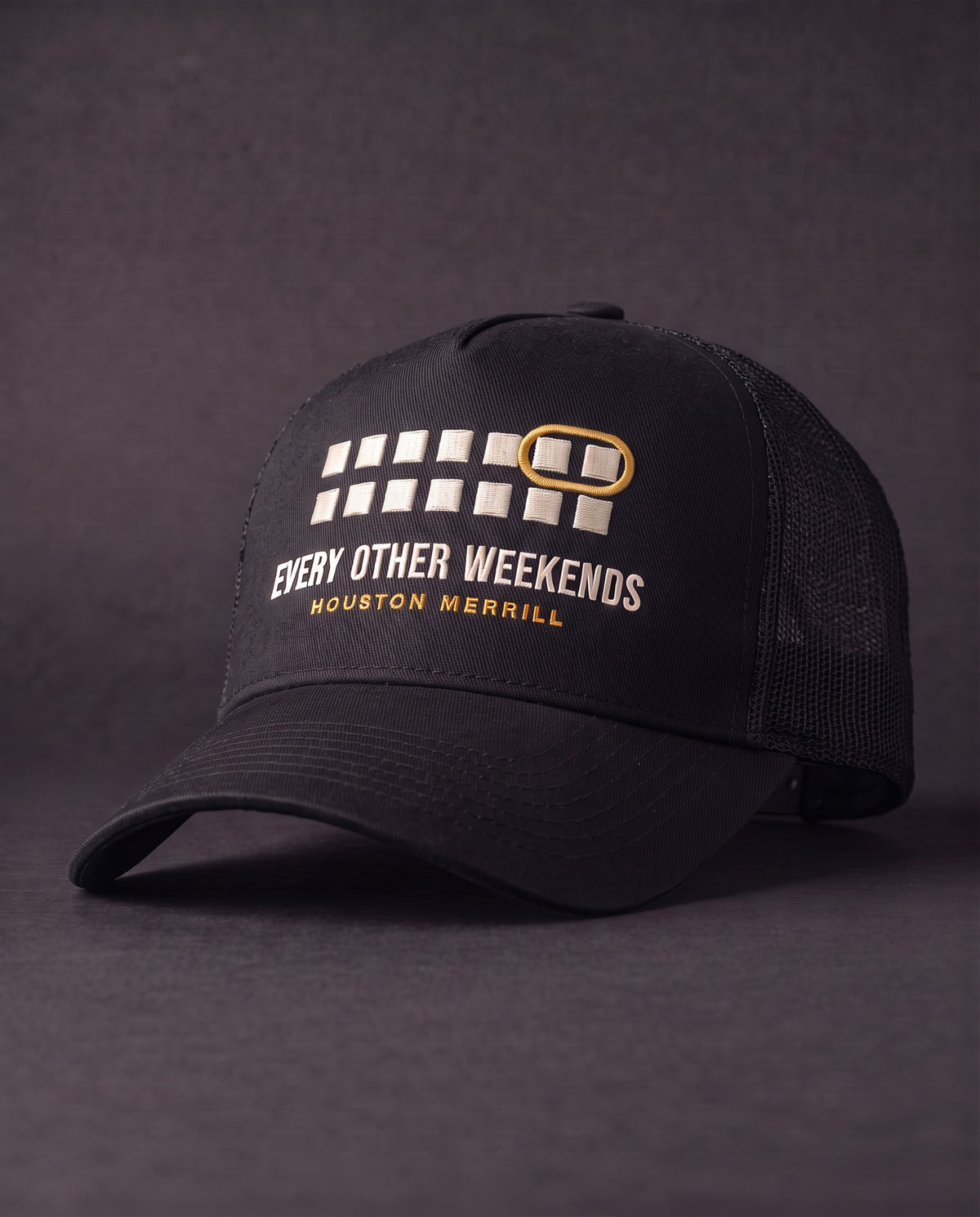 Every Other Weekends A-Frame Trucker — black mesh-back trucker with calendar embroidery